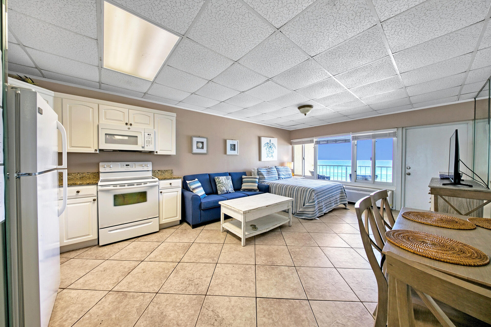 15413 Front Beach Road, Unit 505 Panama City Beach, FL 32413 - Photo 5 of 28 a kitchen with stainless steel appliances kitchen island granite countertop a stove a sink and white cabinets