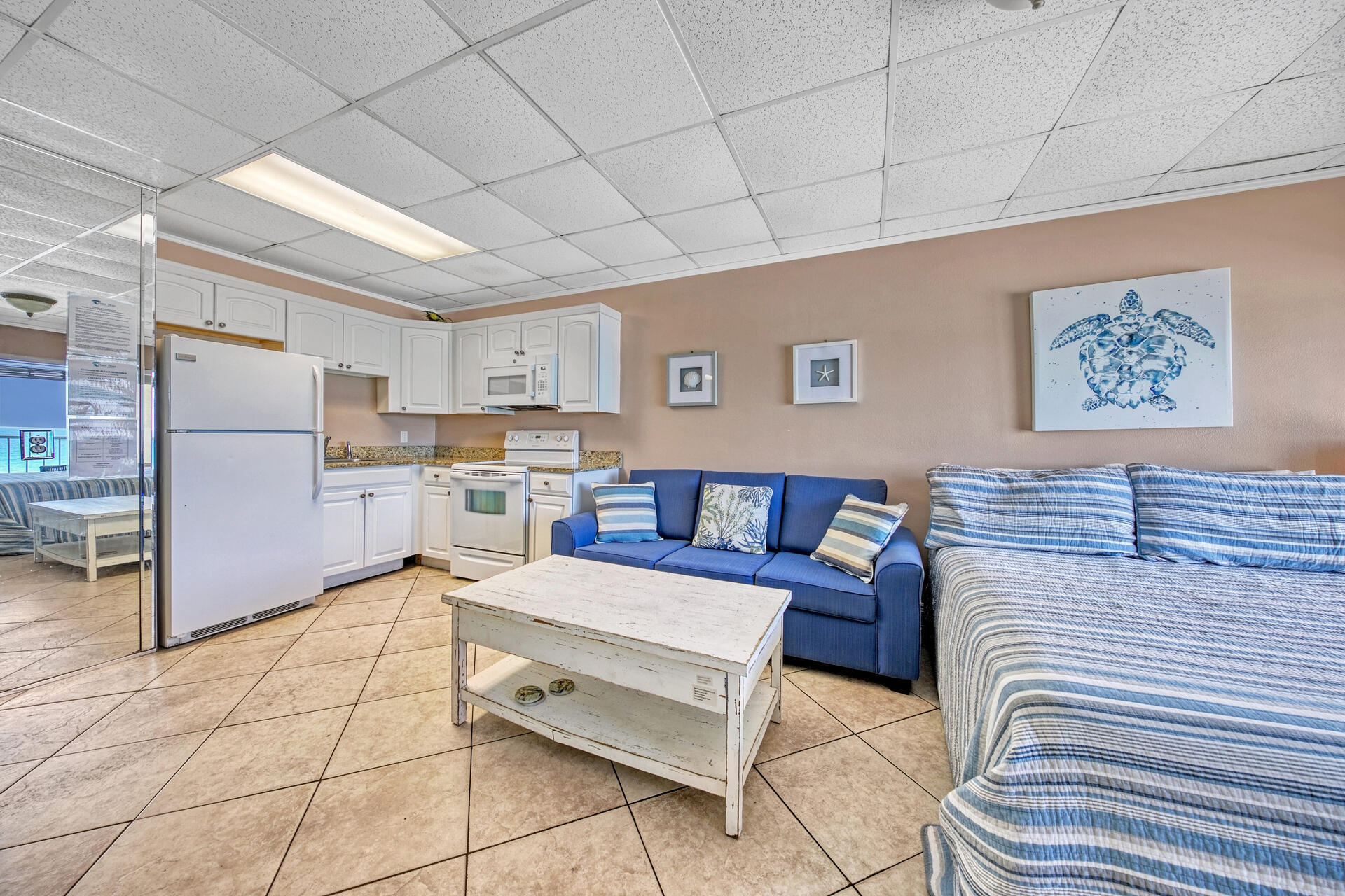 15413 Front Beach Road, Unit 505 Panama City Beach, FL 32413 - Photo 6 of 28 a living room with a couch and a refrigerator