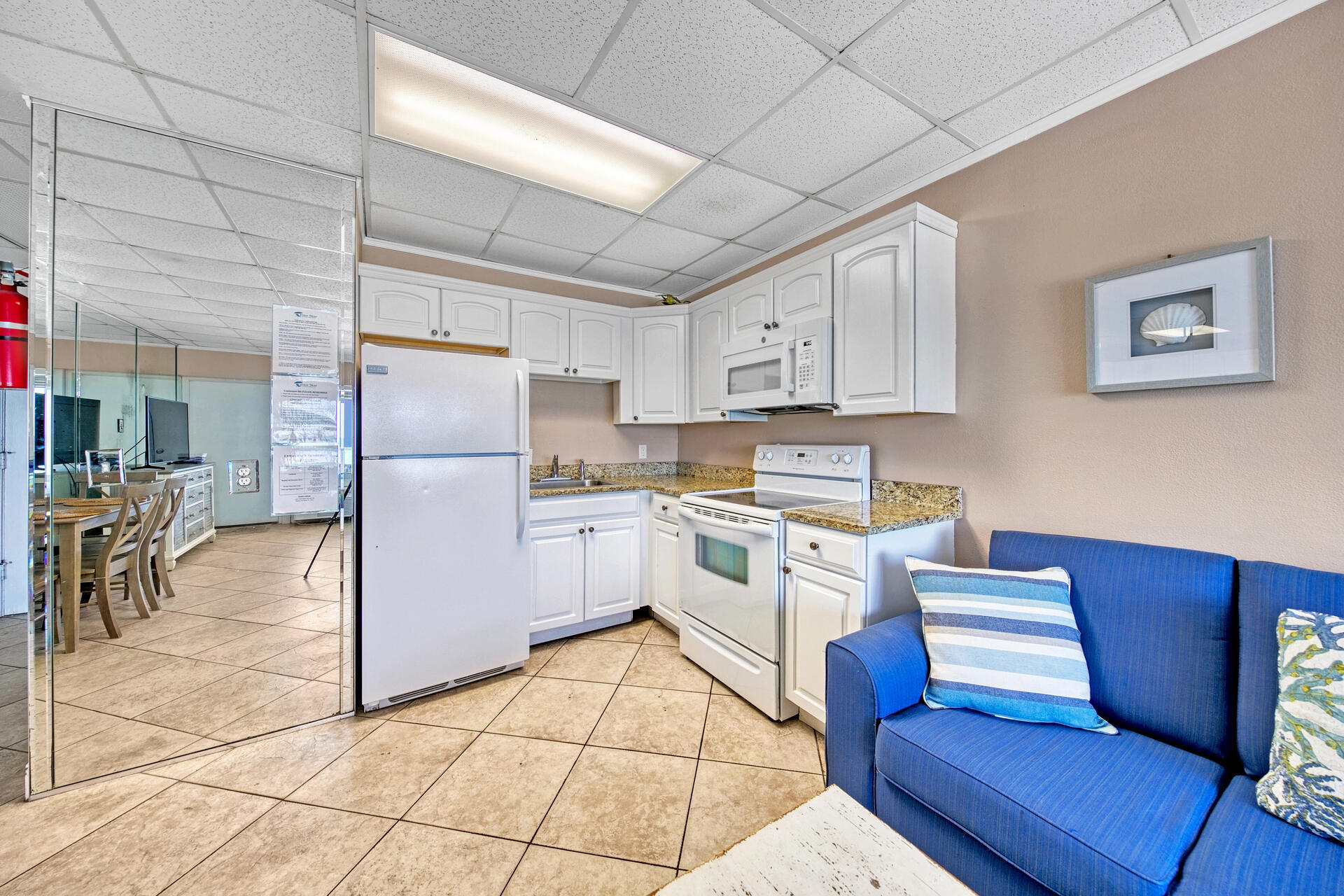15413 Front Beach Road, Unit 505 Panama City Beach, FL 32413 - Photo 8 of 28 a kitchen with cabinets and chairs