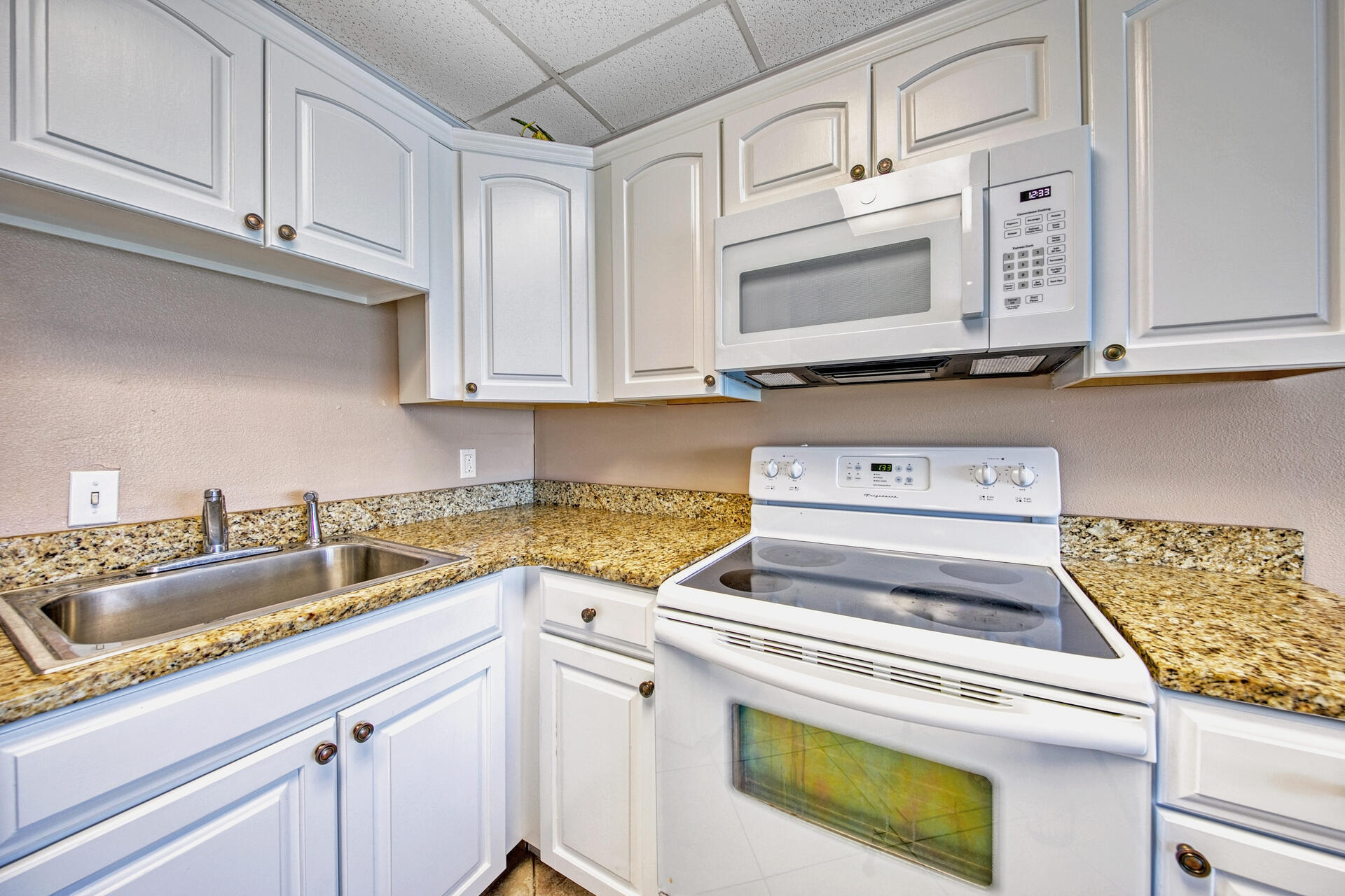 15413 Front Beach Road, Unit 505 Panama City Beach, FL 32413 - Photo 9 of 28 a kitchen with granite countertop cabinets stainless steel appliances and a sink