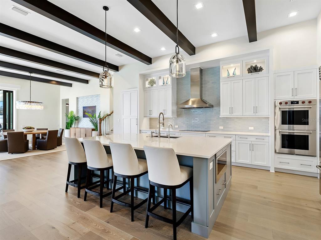 4218 Butte Trail Lakewood Ranch, FL 34211 - Photo 17 of 89 a kitchen with stainless steel appliances kitchen island granite countertop a table chairs sink and cabinets