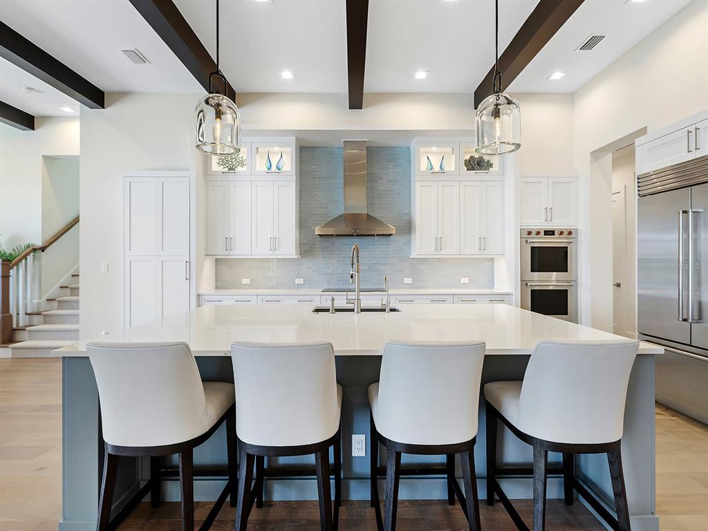 4218 Butte Trail Lakewood Ranch, FL 34211 - Photo 18 of 89 a kitchen with stainless steel appliances granite countertop a table chairs stove and white cabinets