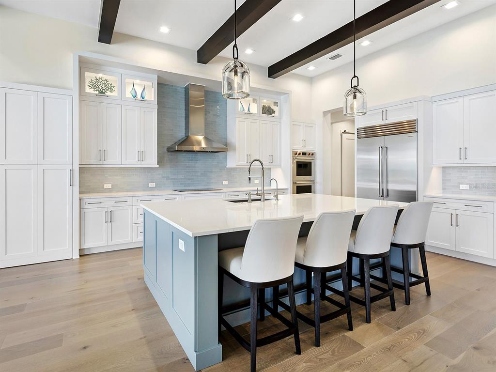 4218 Butte Trail Lakewood Ranch, FL 34211 - Photo 19 of 89 a kitchen with kitchen island a dining table chairs sink and cabinets