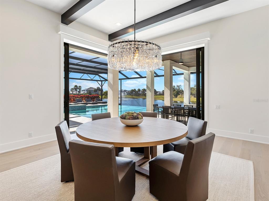 4218 Butte Trail Lakewood Ranch, FL 34211 - Photo 25 of 89 a dining room with furniture a chandelier and window