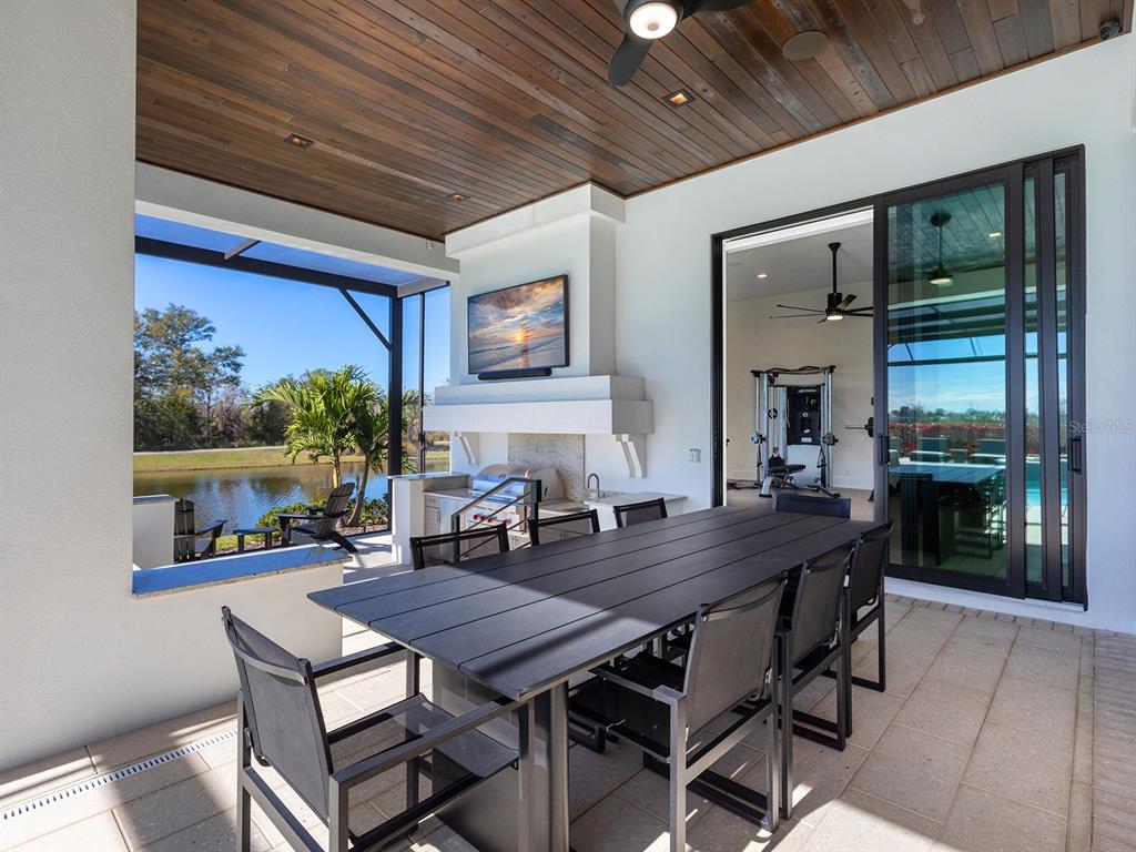 4218 Butte Trail Lakewood Ranch, FL 34211 - Photo 70 of 89 a dining room with furniture a floor to ceiling window and potted plants