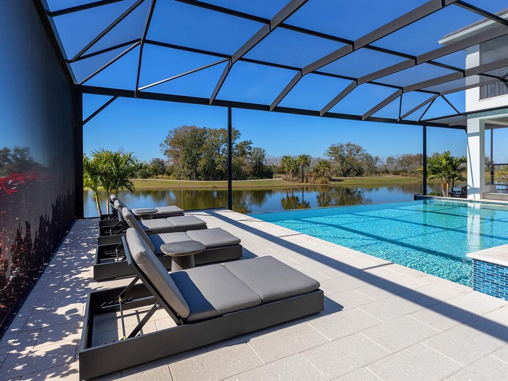 4218 Butte Trail Lakewood Ranch, FL 34211 - Photo 79 of 89 a view of a patio with lawn chairs under an umbrella