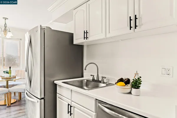 a kitchen with stainless steel appliances a sink a refrigerator and cabinets