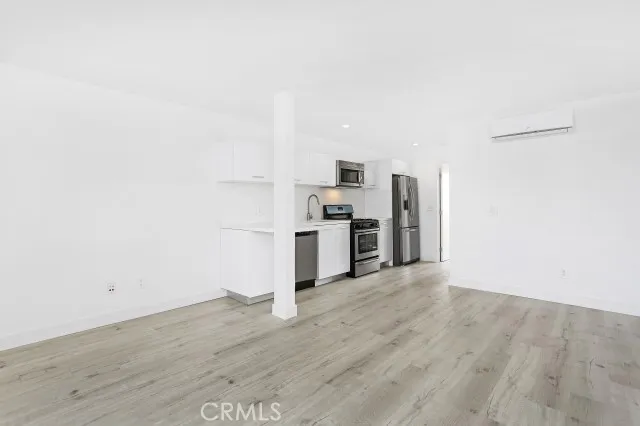 a view of a kitchen with a sink refrigerator and wooden floor