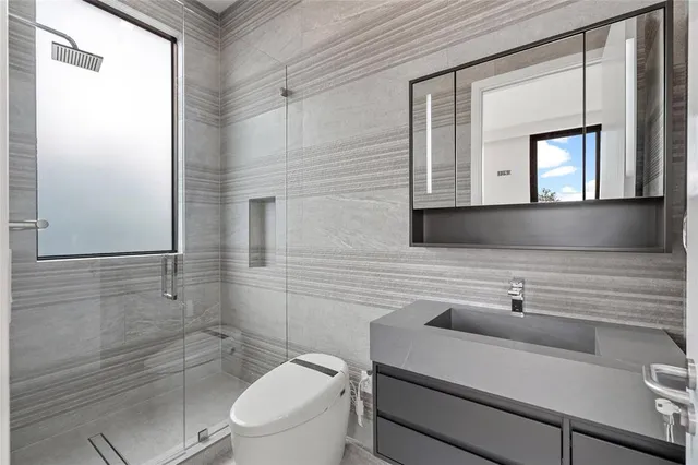 a bathroom with a sink a toilet and mirror