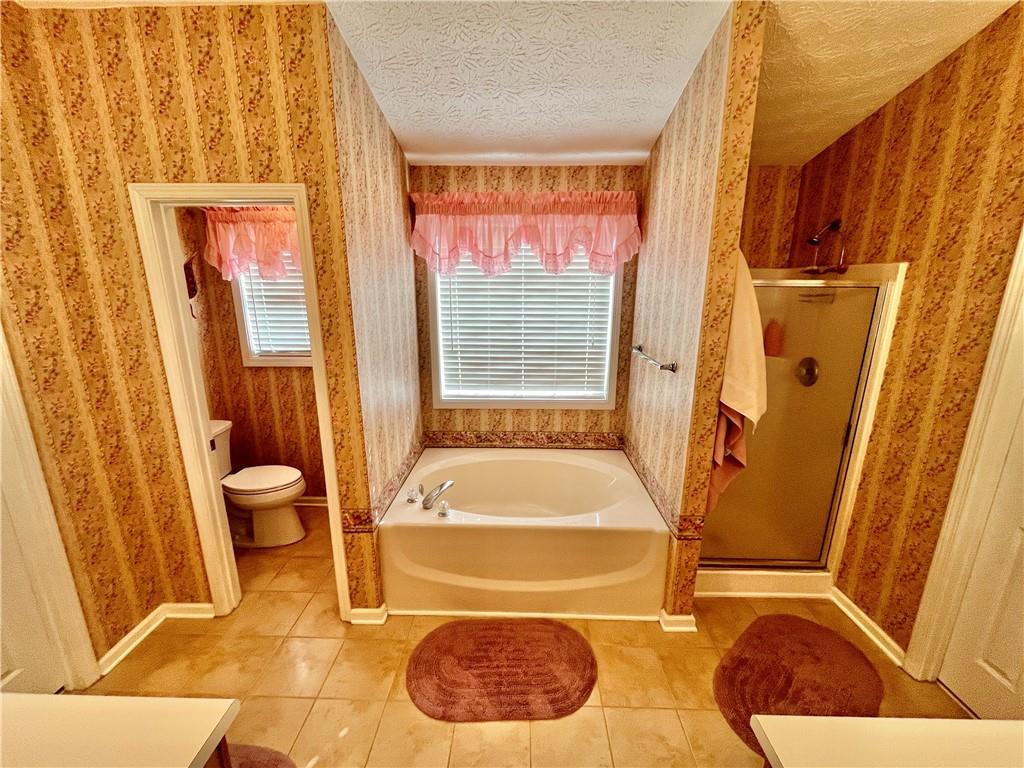 19 Meadow Crest Court Powder Springs, GA 30127 - Photo 11 of 26 a bathroom with a tub and shower