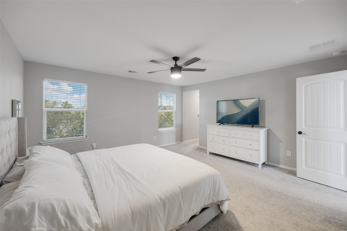 214 Saranac Drive Elgin, TX 78621 - Photo 25 of 37 a bedroom with a large bed and a chandelier