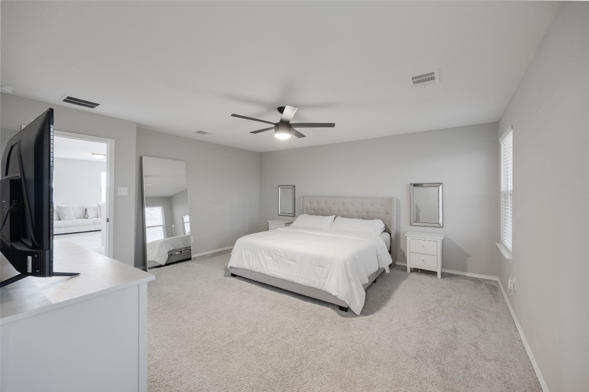 214 Saranac Drive Elgin, TX 78621 - Photo 26 of 37 a spacious bedroom with a bed and a chandelier
