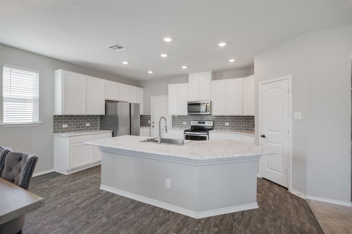 214 Saranac Drive Elgin, TX 78621 - Photo 6 of 37 a kitchen with stainless steel appliances a refrigerator sink stove microwave and cabinets