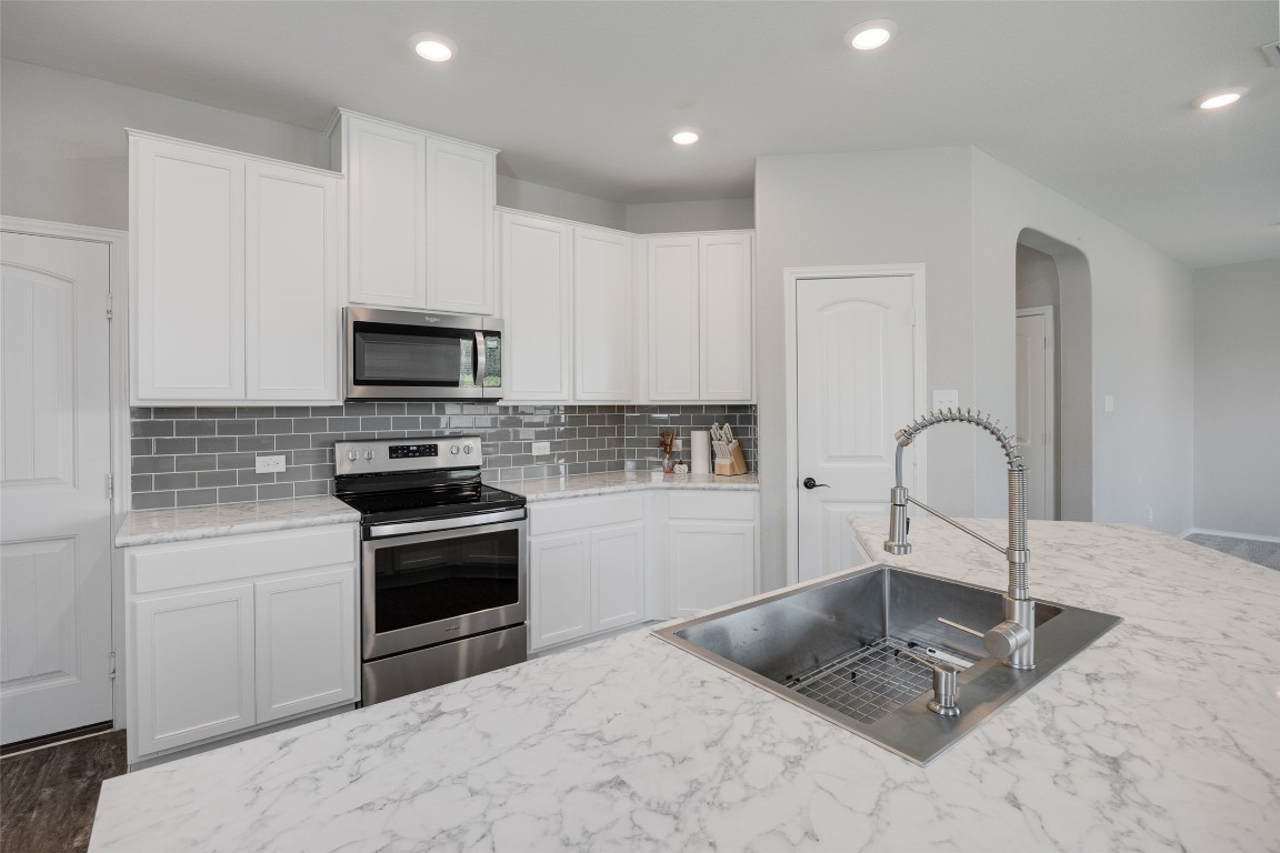 214 Saranac Drive Elgin, TX 78621 - Photo 9 of 37 a kitchen with a sink a stove and cabinets