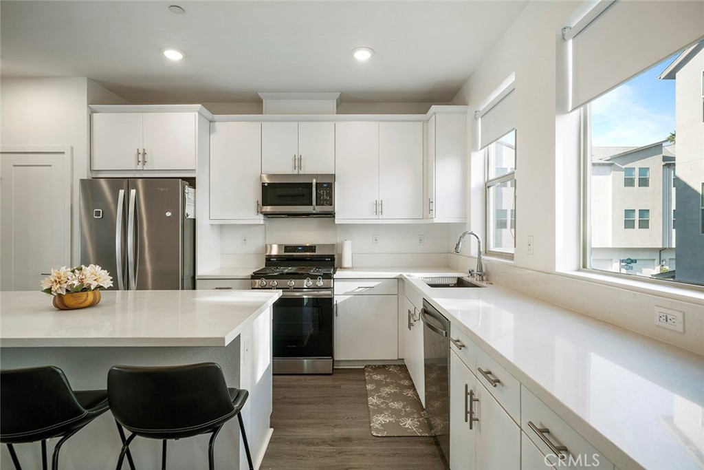 229 Scratch Road Covina, CA 91722 - Photo 9 of 29 a kitchen with stainless steel appliances a stove a sink a microwave a refrigerator and cabinets