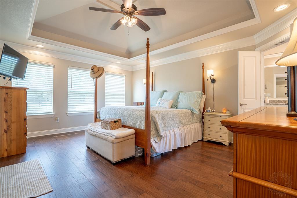 1920 Meander Road Granbury, TX 76049 - Photo 16 of 40 Spacious bedroom featuring wood-finish flooring, a tray ceiling with crown molding, recessed lighting, and multiple windows with blinds