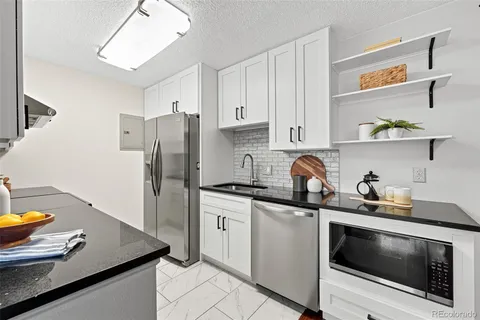 a kitchen with stainless steel appliances a stove microwave and refrigerator