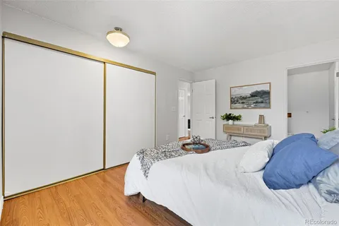 a bedroom with a bed and a painting on the wall