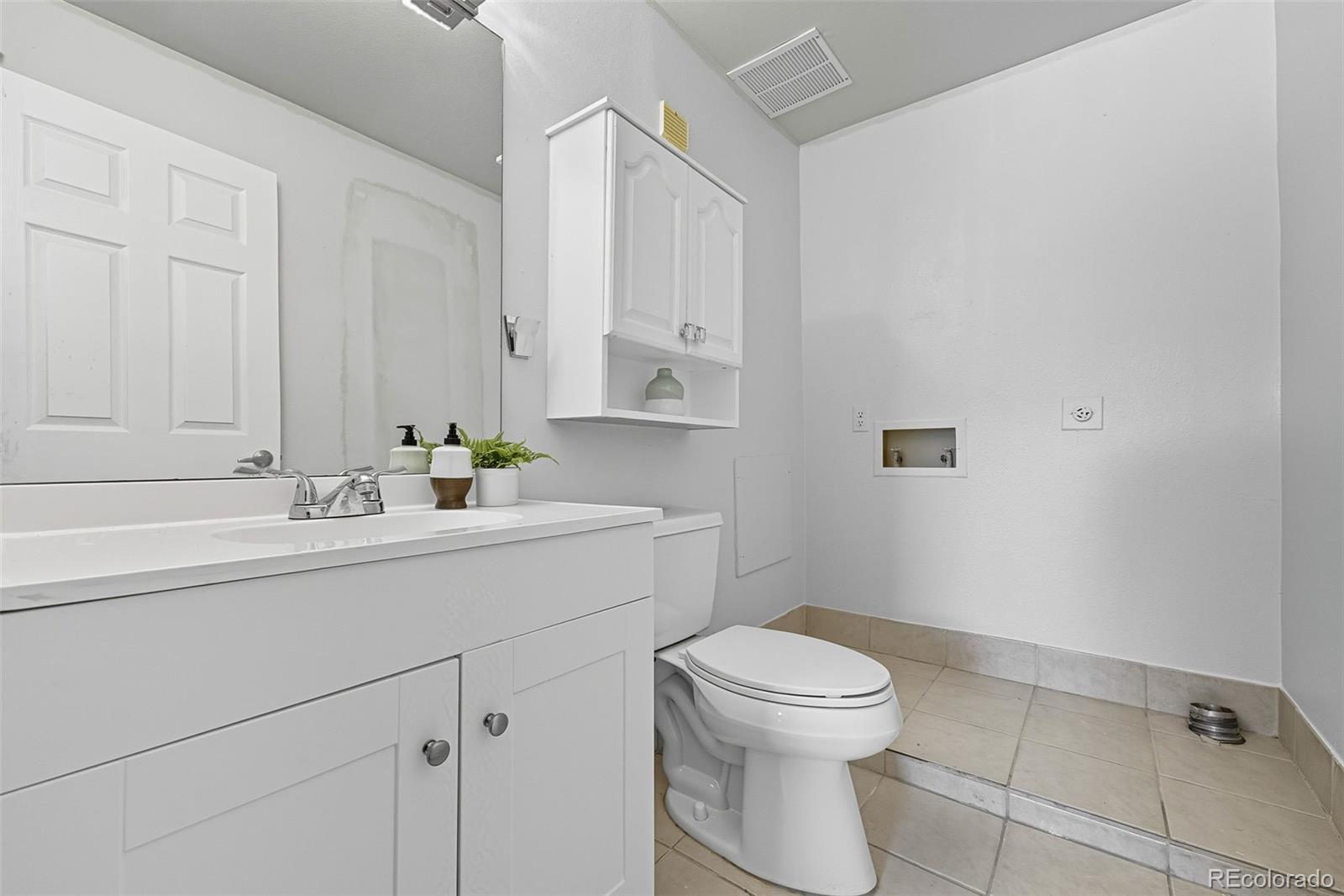 381 South Ames Street, Unit C204 Lakewood, CO 80226 - Photo 20 of 34 a bathroom with a sink a toilet and mirror