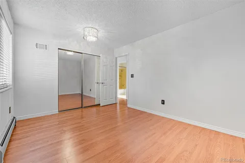 an empty room with wooden floor and mirror