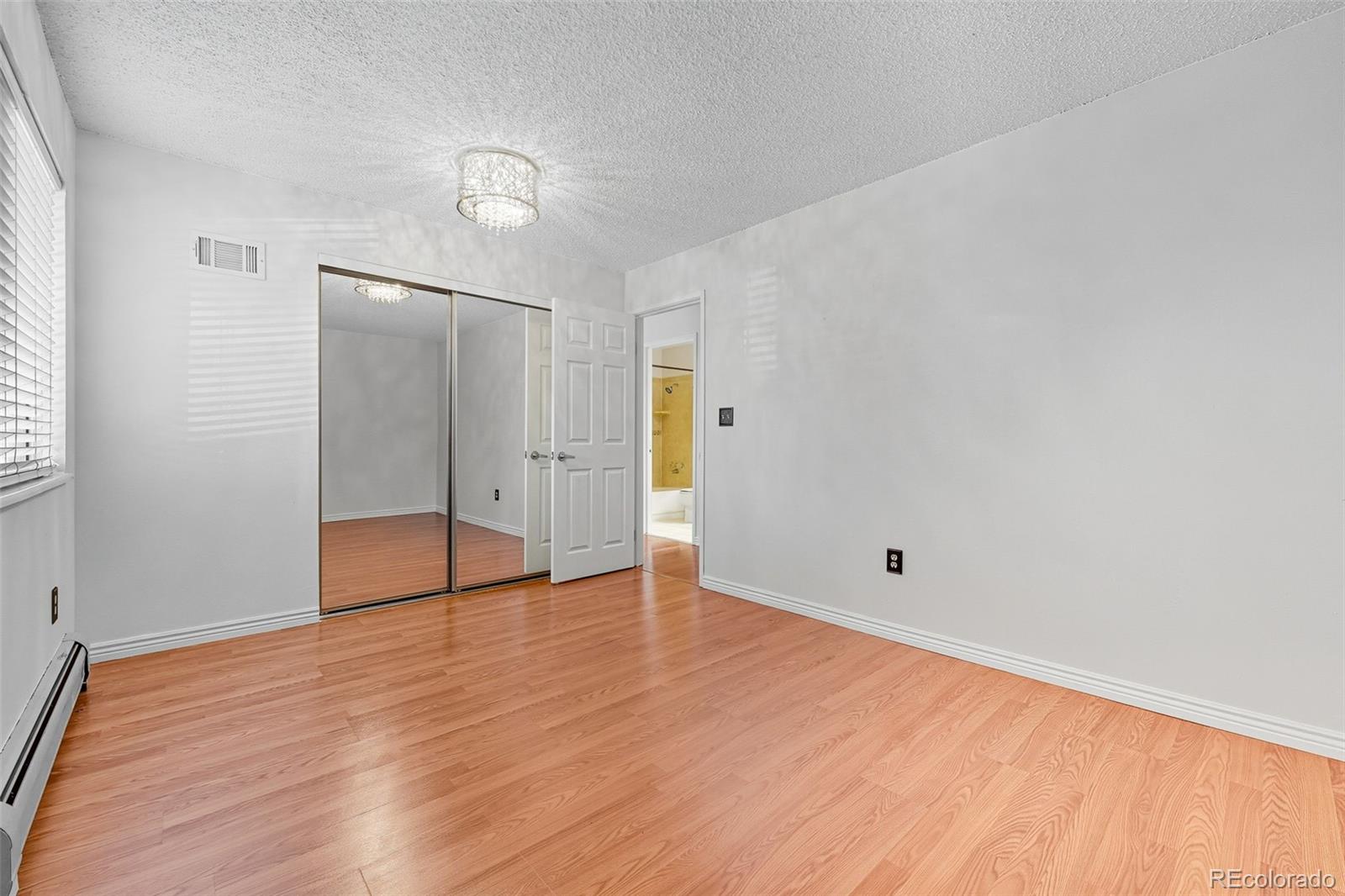 381 South Ames Street, Unit C204 Lakewood, CO 80226 - Photo 24 of 34 an empty room with wooden floor and mirror