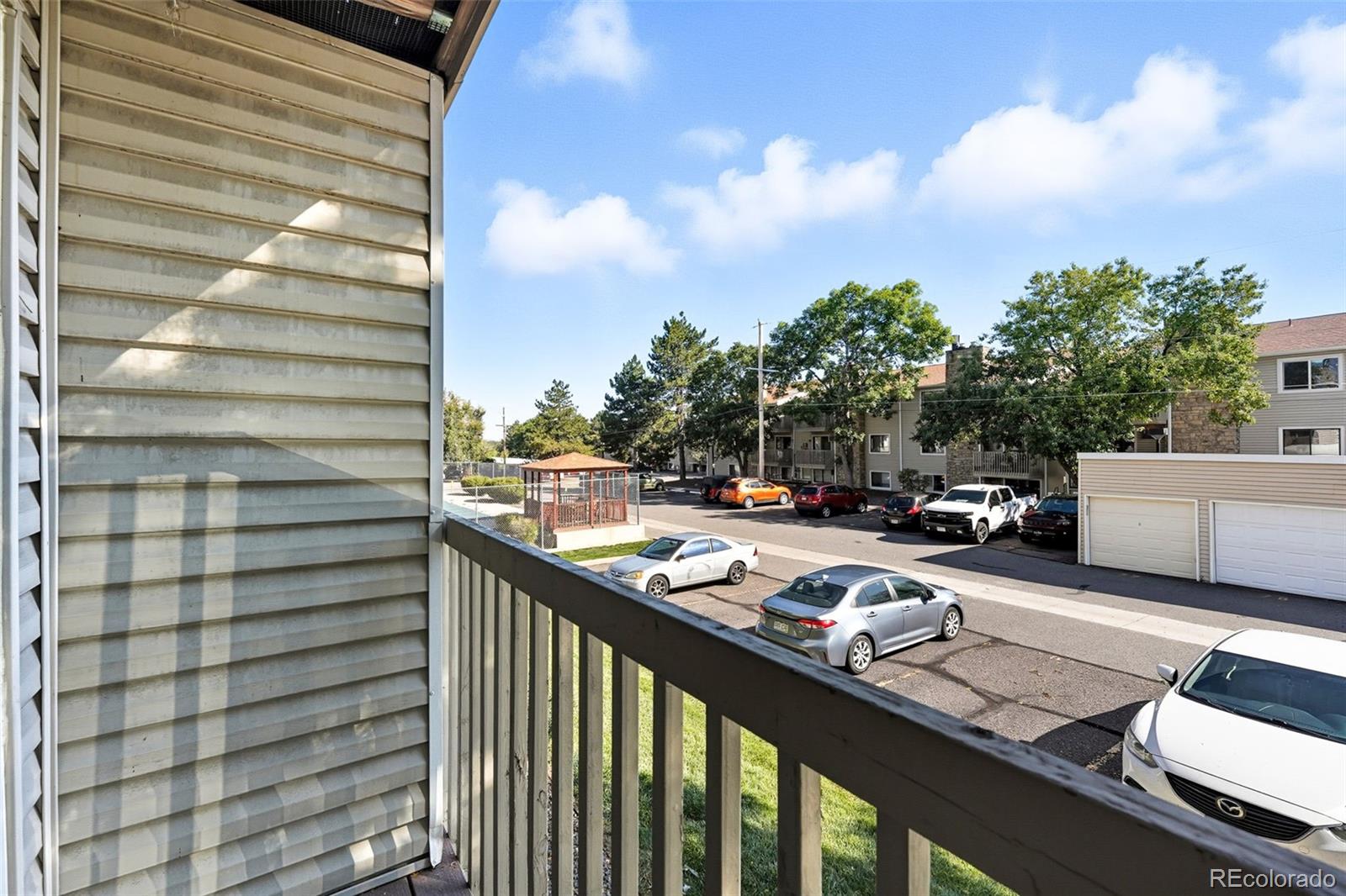 381 South Ames Street, Unit C204 Lakewood, CO 80226 - Photo 30 of 34 a view of a balcony with two chairs and a potted plant