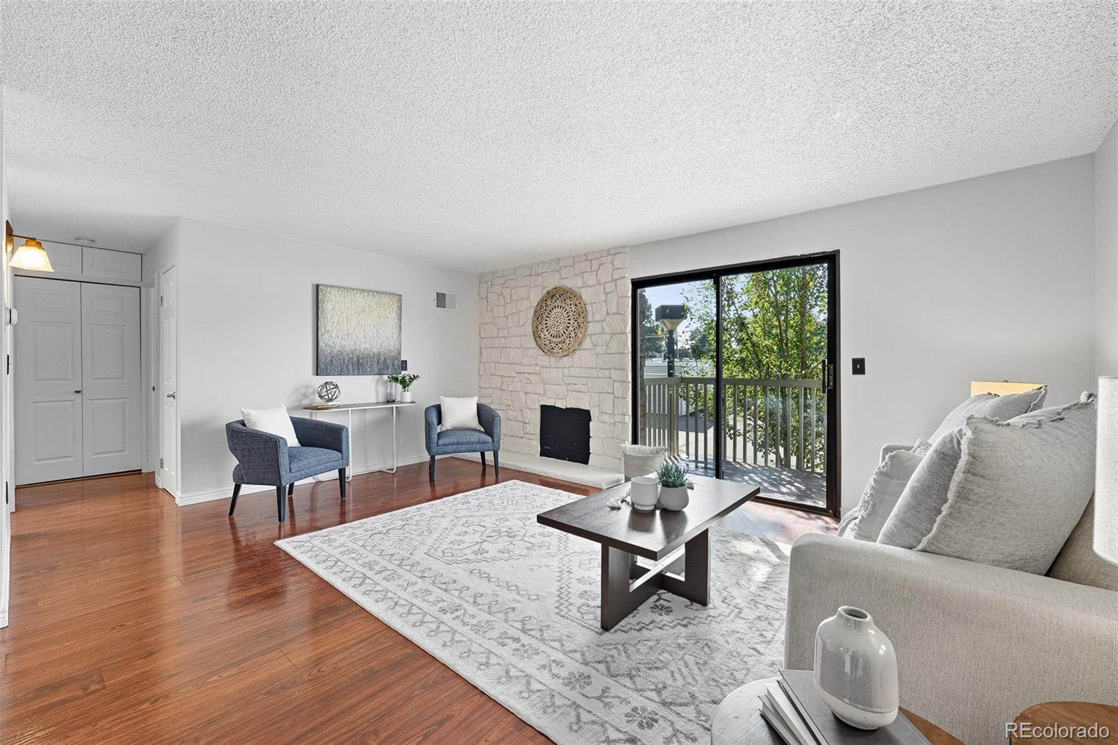 381 South Ames Street, Unit C204 Lakewood, CO 80226 - Photo 3 of 34 a living room with furniture a fireplace and a table