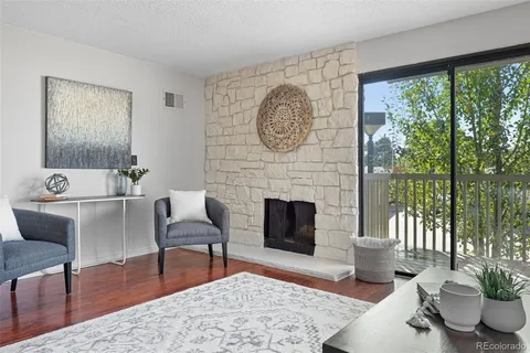 a living room with furniture a large window and a fireplace