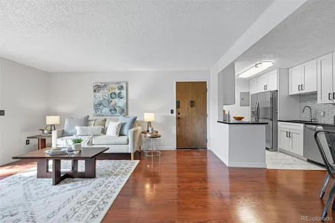 a living room with furniture and a wooden floor