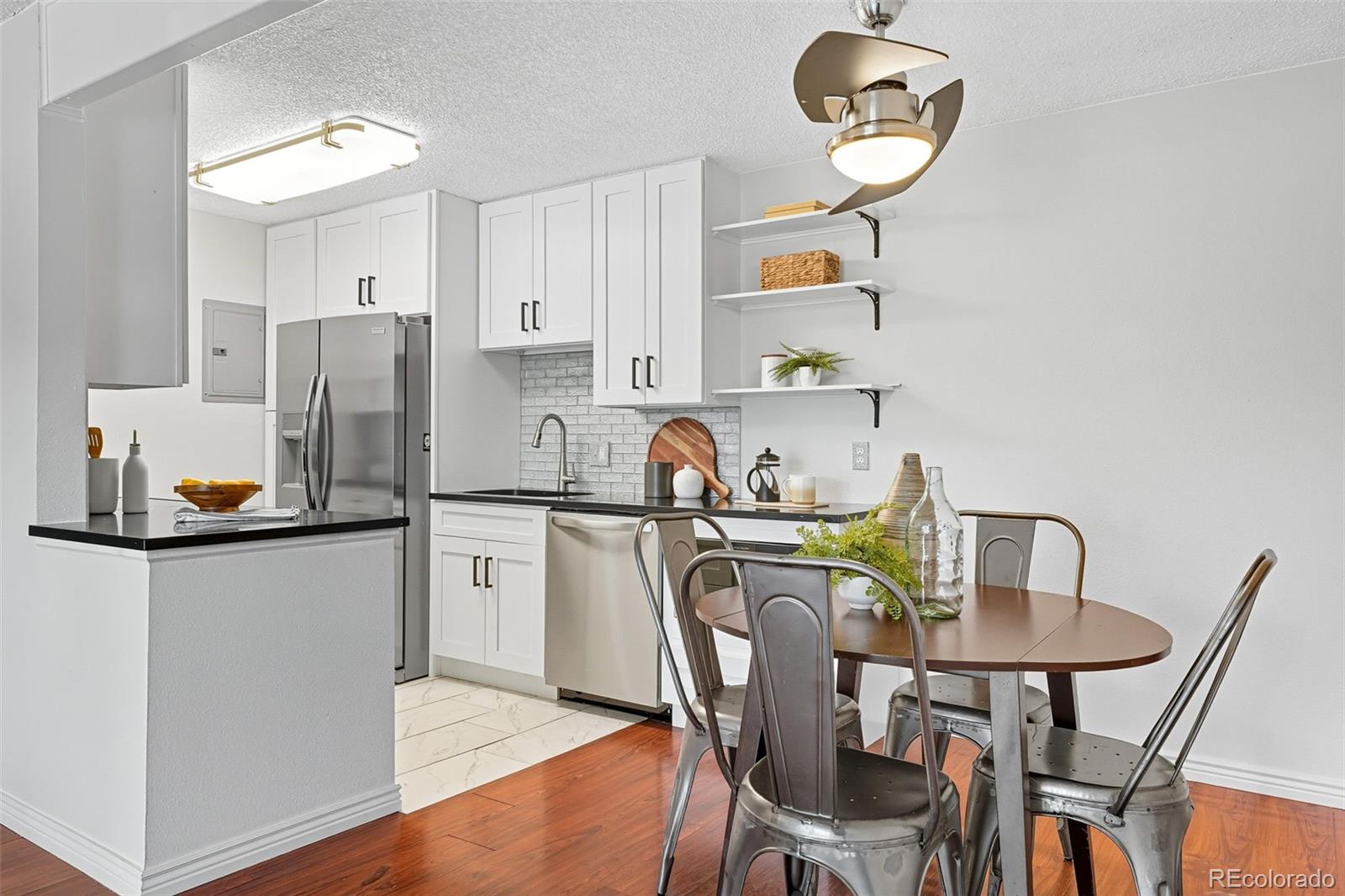 381 South Ames Street, Unit C204 Lakewood, CO 80226 - Photo 10 of 34 a kitchen with stainless steel appliances granite countertop a dining table chairs and a refrigerator