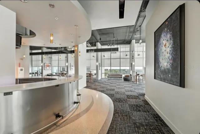 a view of a living room with floor to ceiling window and wooden floor