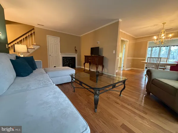 a living room with furniture a fireplace and a chandelier