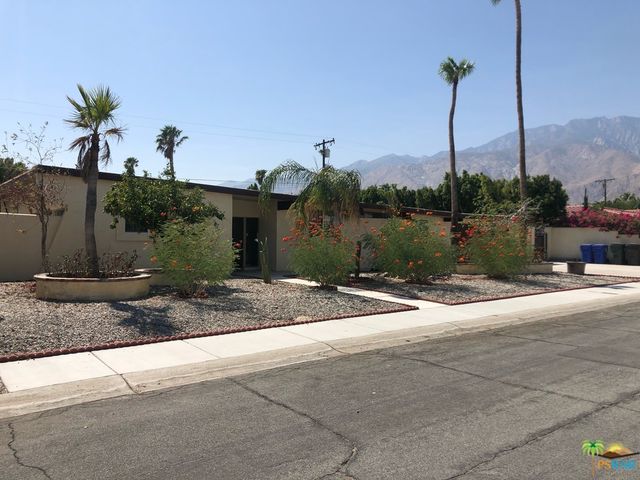 a backyard of a house with a table and chairs