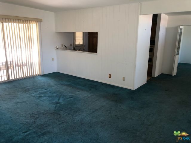 a view of a livingroom with an empty space and a window