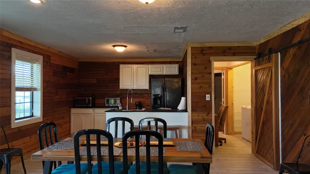 a kitchen with stainless steel appliances granite countertop a kitchen island a table and chairs
