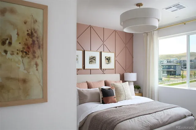 a bedroom with a bed and a painting on the wall