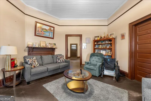 a living room with furniture and a painting on the wall