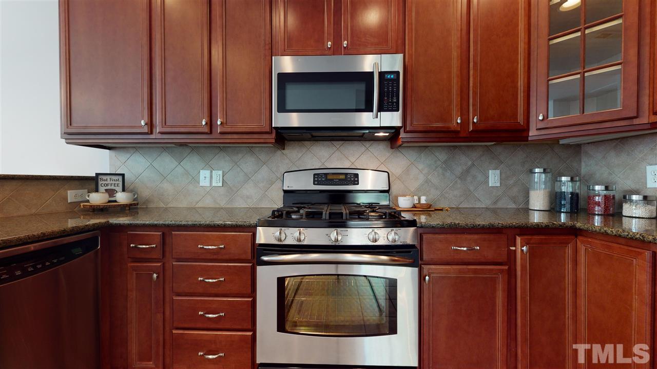 11245 Maplecroft Court Raleigh, NC 27617 - Photo 5 of 30 Chef’s kitchen feat. 42’ cherry cabinets, granite counters, tile backsplash, SS appliances, & gas range!