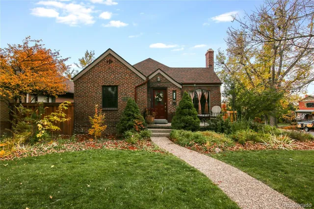 a front view of a house with a yard and trees