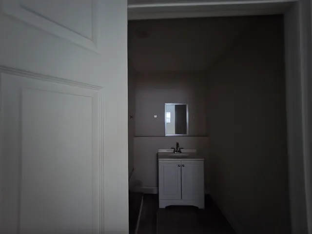 a bathroom with a sink a light fixture and a toilet