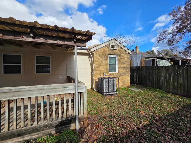 a view of a house with backyard and wooden fence