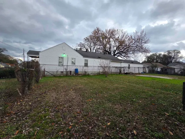 a view of a house with backyard and sitting area