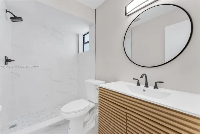 a bathroom with a sink a toilet and a mirror