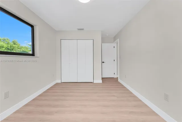 a view of an empty room with wooden floor