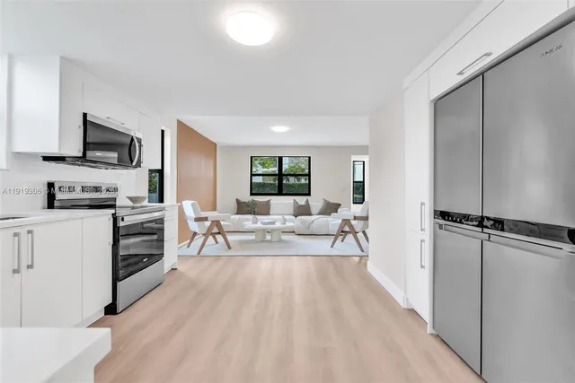 a living room with stainless steel appliances furniture and a rug