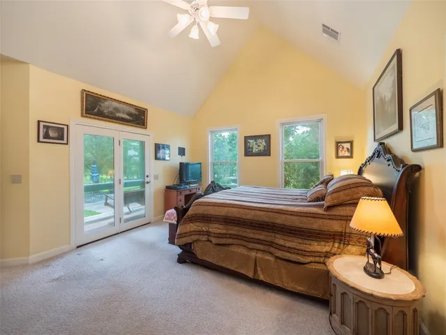 a kitchen with stainless steel appliances granite countertop a stove a sink a microwave a refrigerator and white cabinets with wooden floor