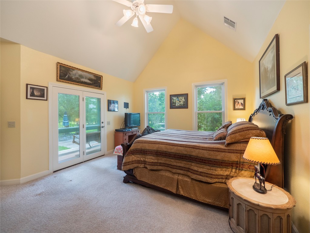 13503-13511 Carpenter Lane Manchaca, TX 78652 - Photo 25 of 40 a spacious bedroom with a bed a chandelier and large window