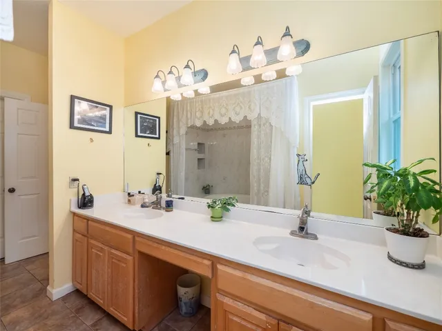 a spacious bedroom with a bed a chandelier and large window