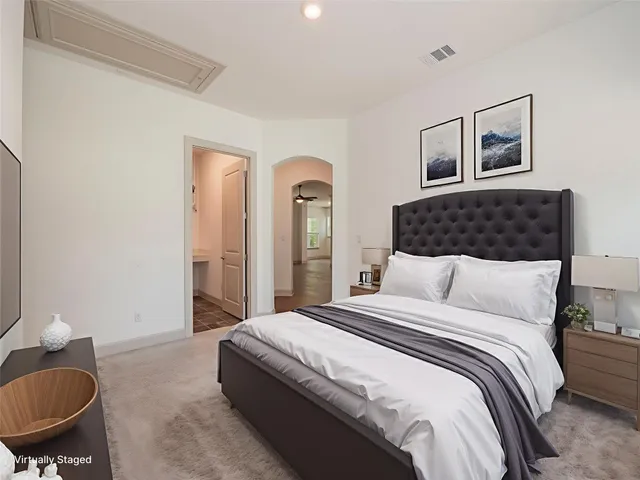 a spacious bedroom with a bed a couch and dresser