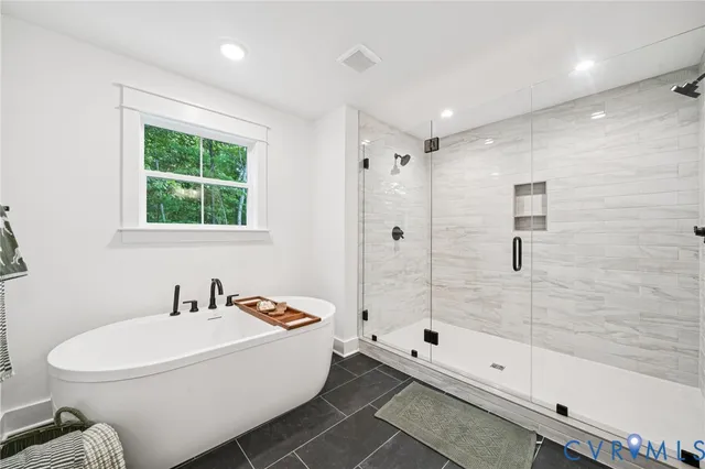 a white bath tub sitting next to a white toilet and a shower